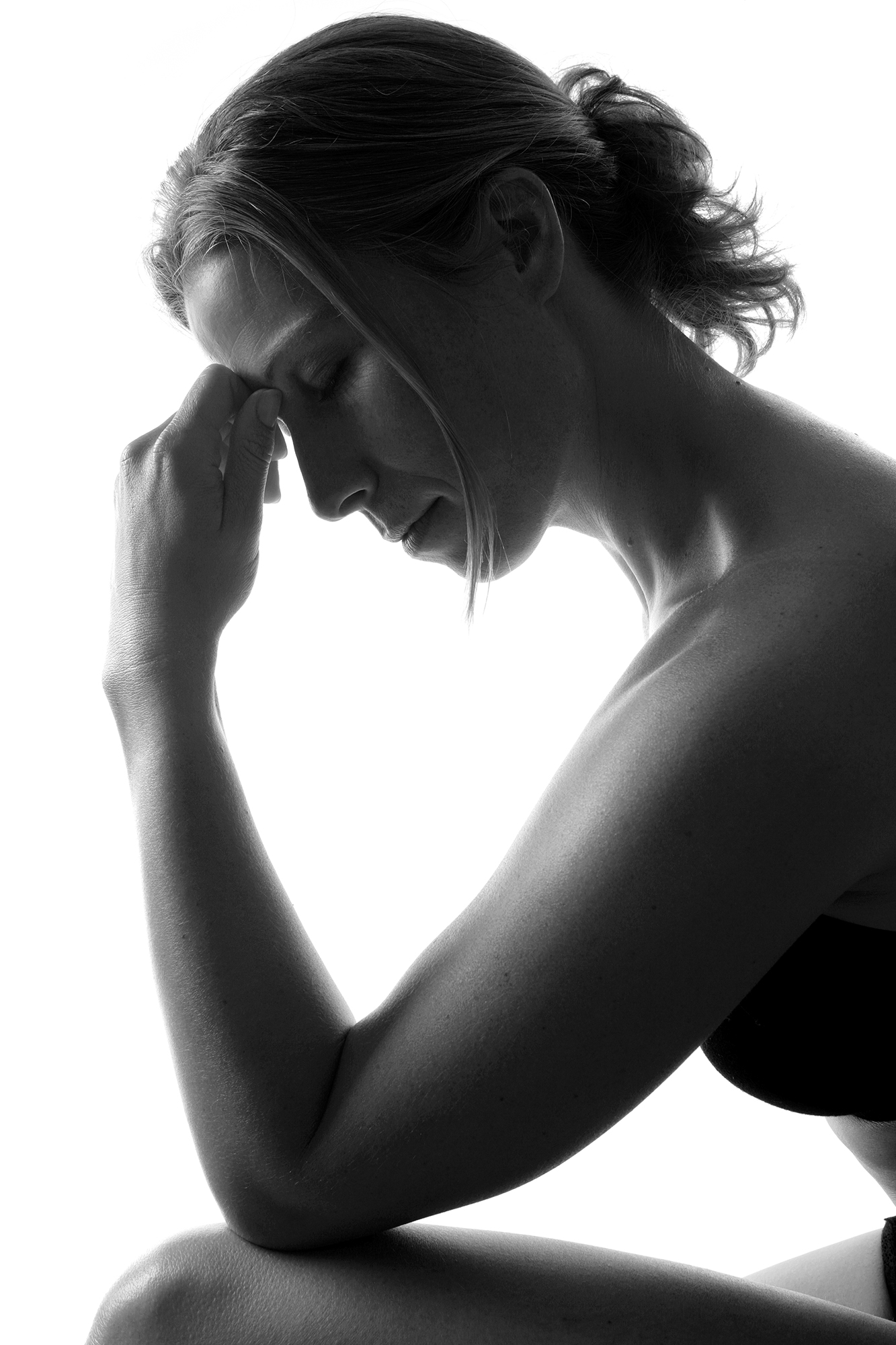 Kvinna med smärta som håller på sin panna