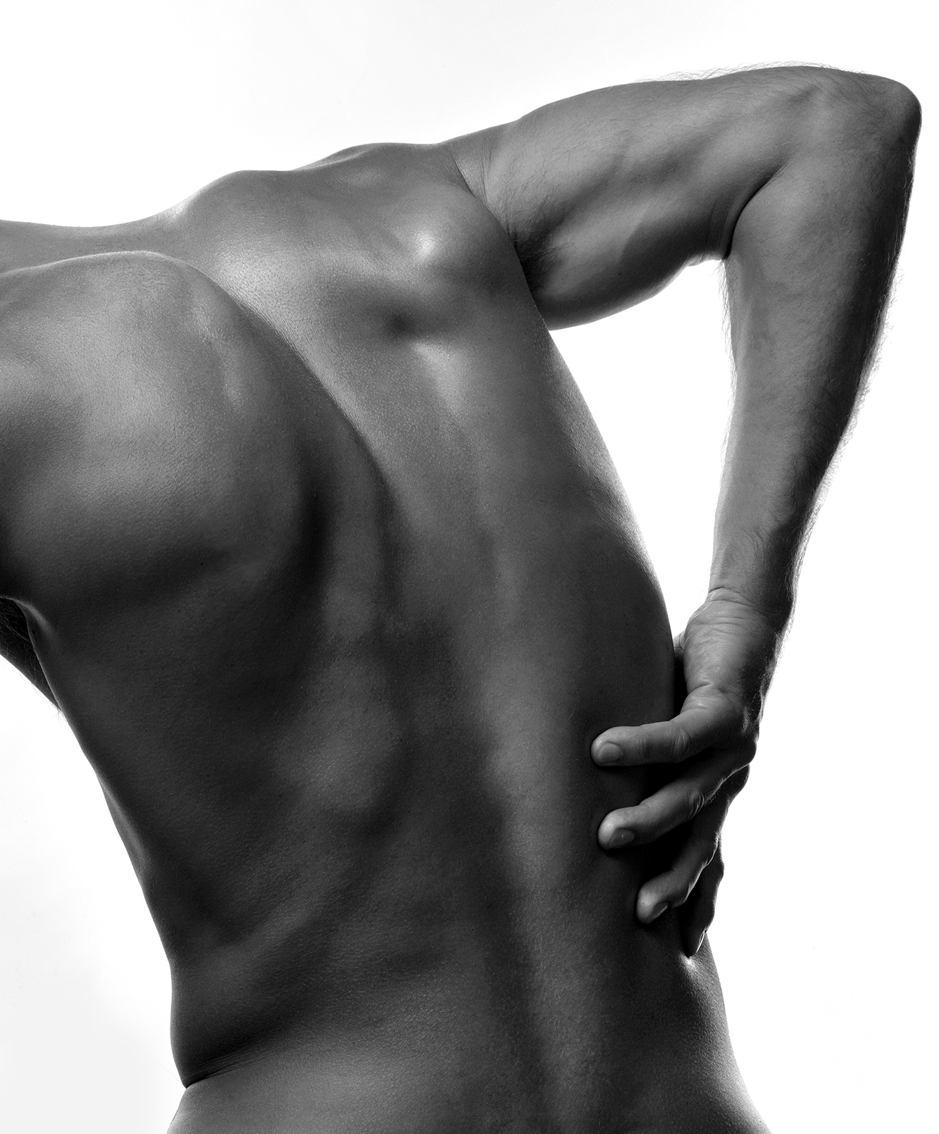 Man med smärta som håller handen på ryggen