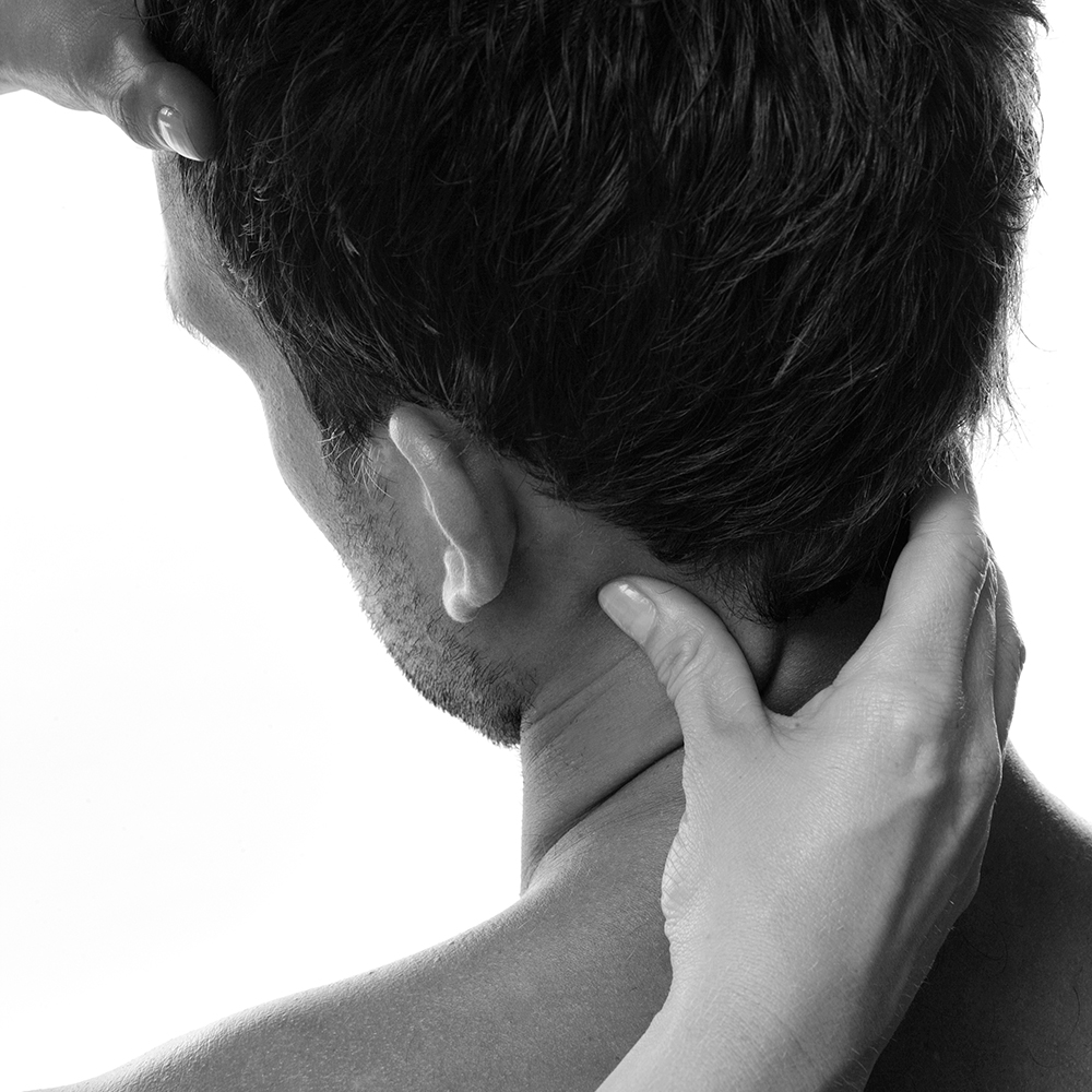 Kvinnohänder som håller stabiliserande om en mans nacke och panna