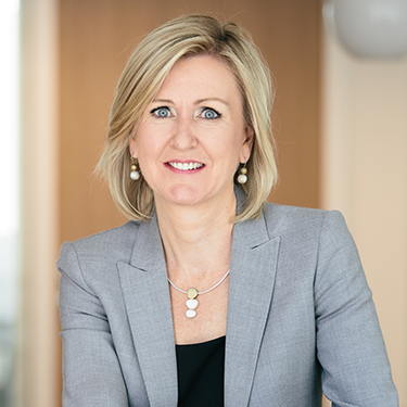 Ann Mettler in a grey blazer smiling at the camera