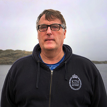 Fredrik Grondahl standing outside infront of some water and an island in the background