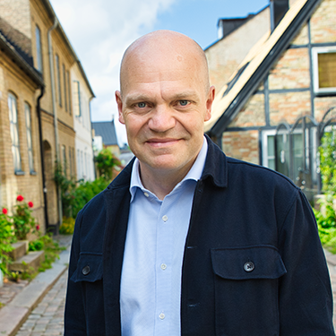 Anders Almgren standing on a street in Lund on a sunny day.