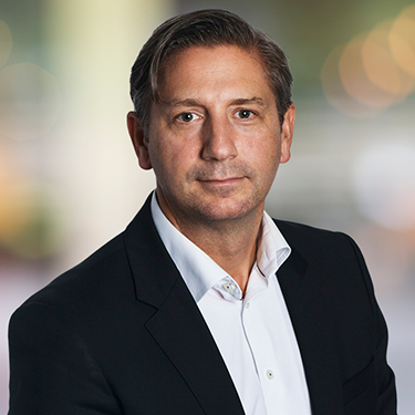 Christian Lindfors in a suit in front of a blurred background