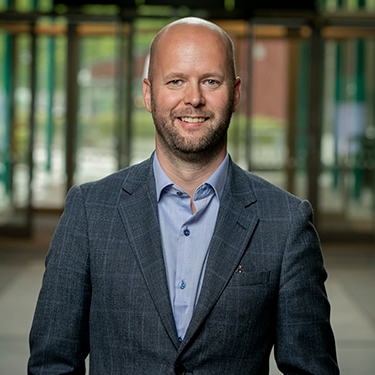 Medium close up of Kristoffer Skjutare in a suit in a building