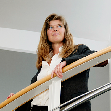 Sindra Petersson Årsköld standing by a stair railing looking up.