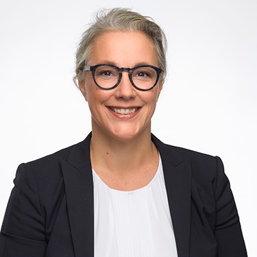 Annika Remaeus smiling at the camera in front of a white background