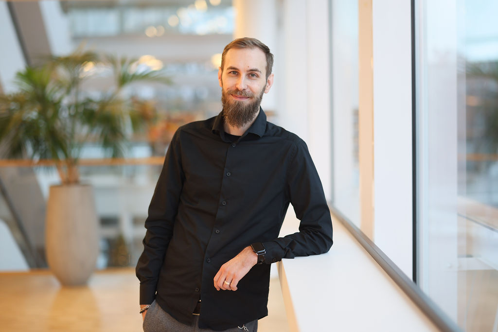 Porträtt man med kort hår, skägg och svart skjorta
